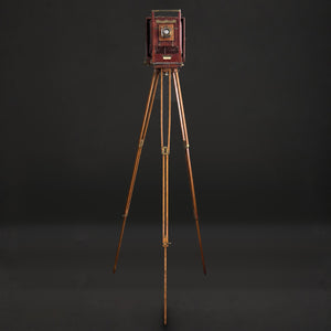 Cámara de fuelle roja con tripié. Decorativa, no funciona. Ca. 1905–1925.