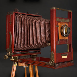 Cámara de fuelle roja con tripié. Decorativa, no funciona. Ca. 1905–1925.